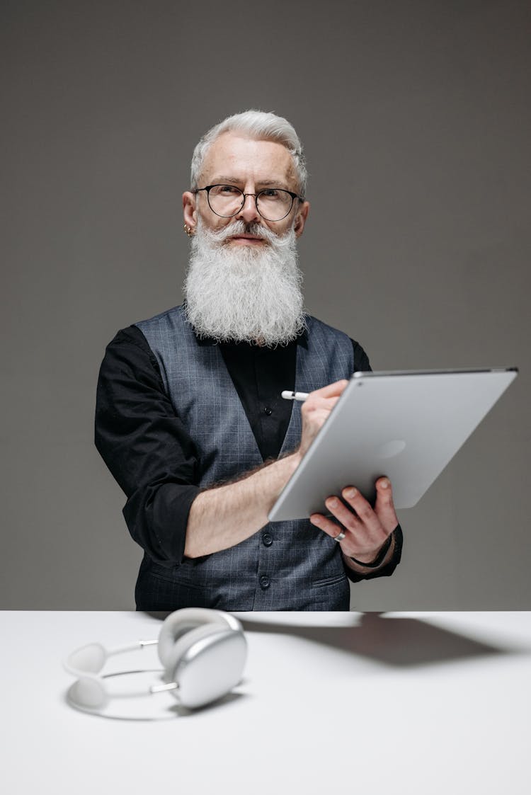 An Elderly Man Holding A Tablet