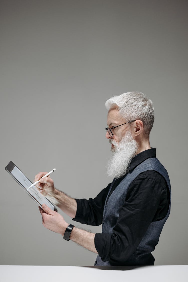 A Bearded Man Drawing On A Digital Tablet