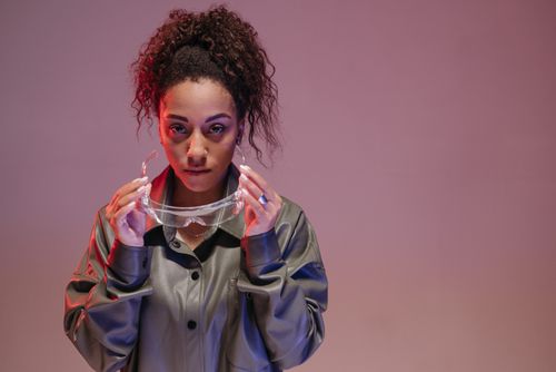 Free A young woman holding protective goggles in a studio setting with a modern vibe. Stock Photo