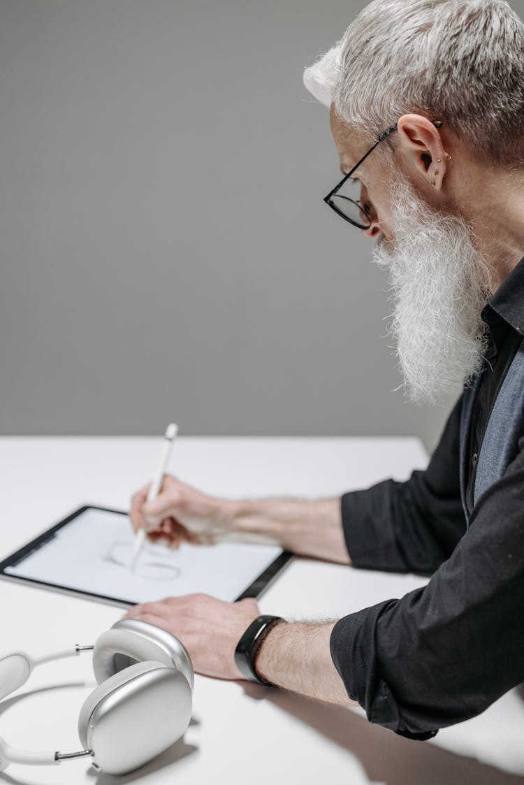 A Bearded Man Drawing On A Digital Tablet