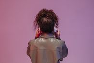 Person in Gray Coat Covering Face With Hair