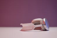 Close-Up Shot of Gray Headphones on White Surface