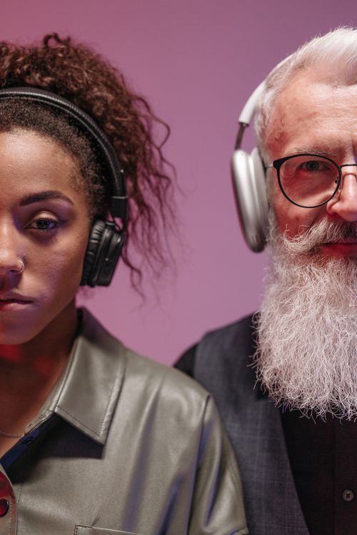 Free A young woman and an elderly man with headphones sharing a music moment. Stock Photo