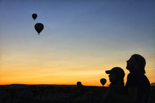 A Silhouette of a Couple Watching Hot Air Balloons