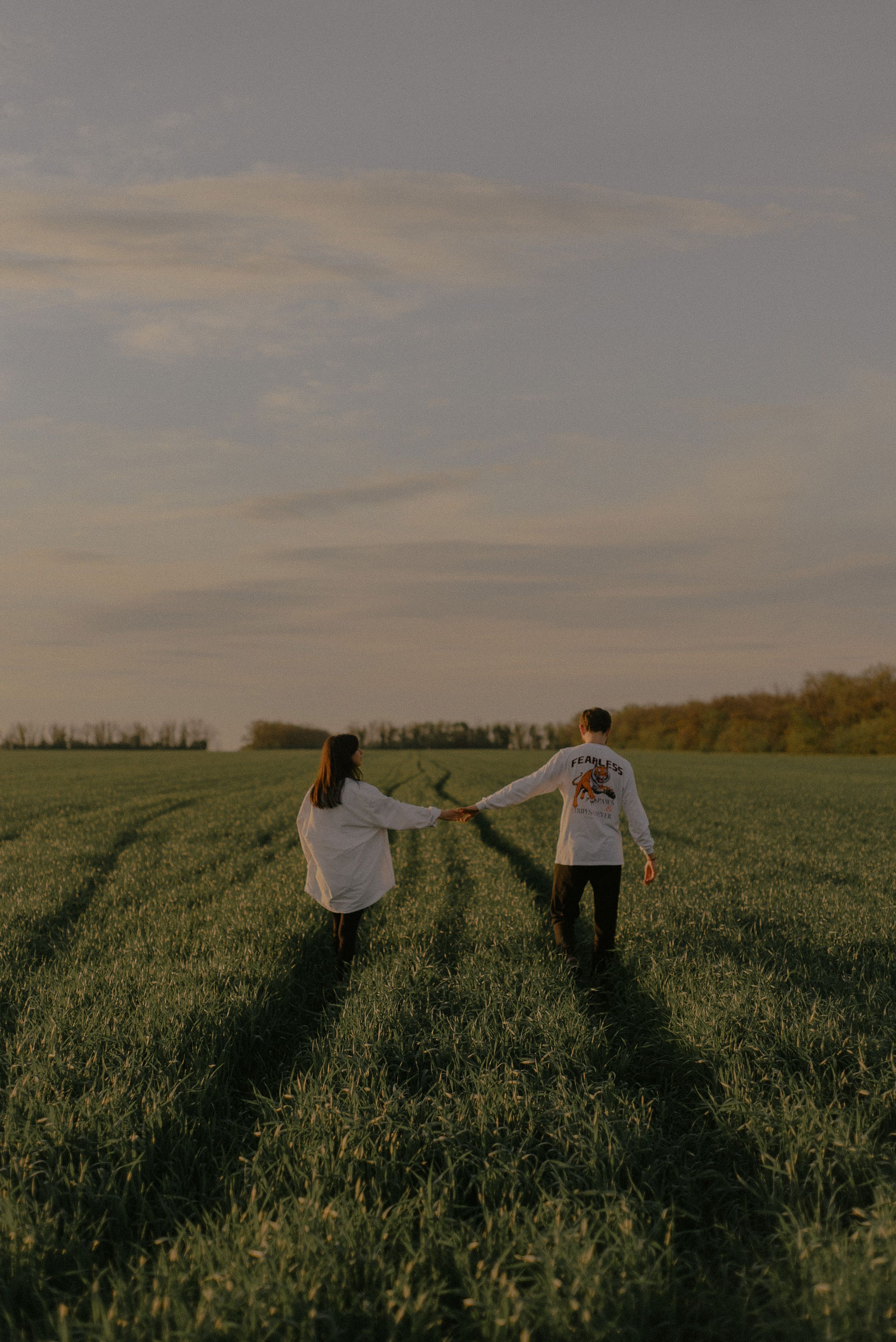 Man and Woman Holding Hands on Green Grass Field · Free Stock Photo