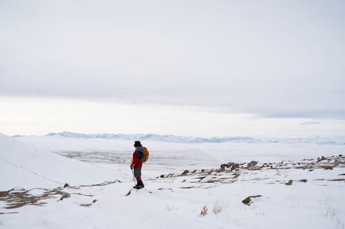 Person Standing on Snow Covered Ground