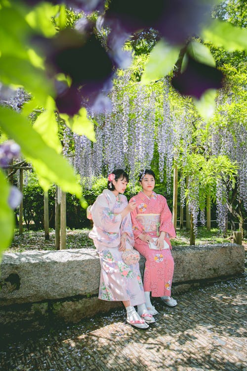 Women Sitting Under the Purple Flowers