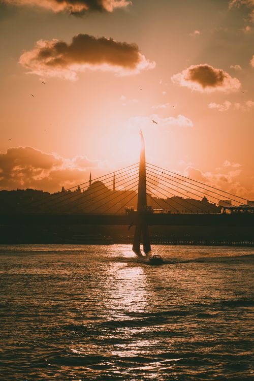 Free Captivating sunset over the Golden Horn in İstanbul with a boat silhouette and city skyline. Stock Photo