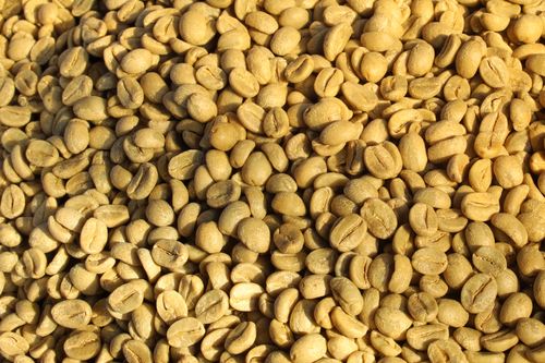 Free A heap of raw coffee beans in bright sunlight, showcasing texture and detail. Stock Photo