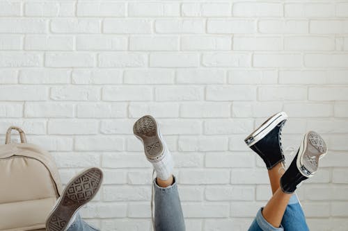 Free Photo of People's Feet Wearing Black and White Sneakers Stock Photo