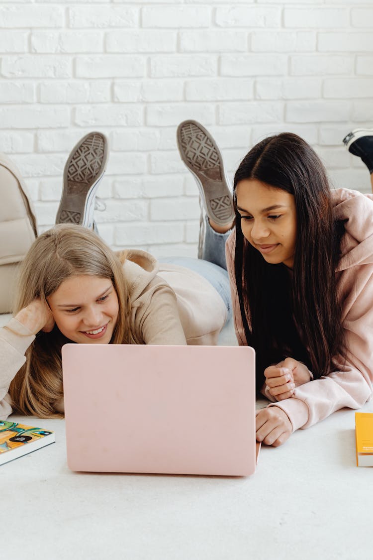 Teens Lying On The Floor Using A Laptop