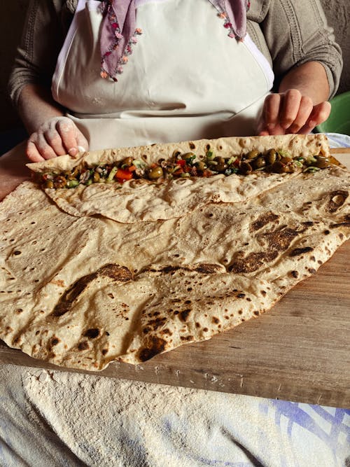 Woman Rolling Traditional Flatbread with Filling 