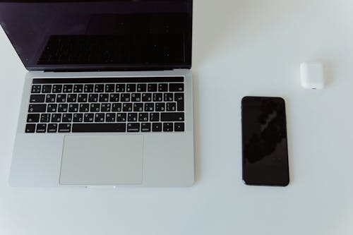 Free An Iphone and Macbook Pro on White Table Stock Photo
