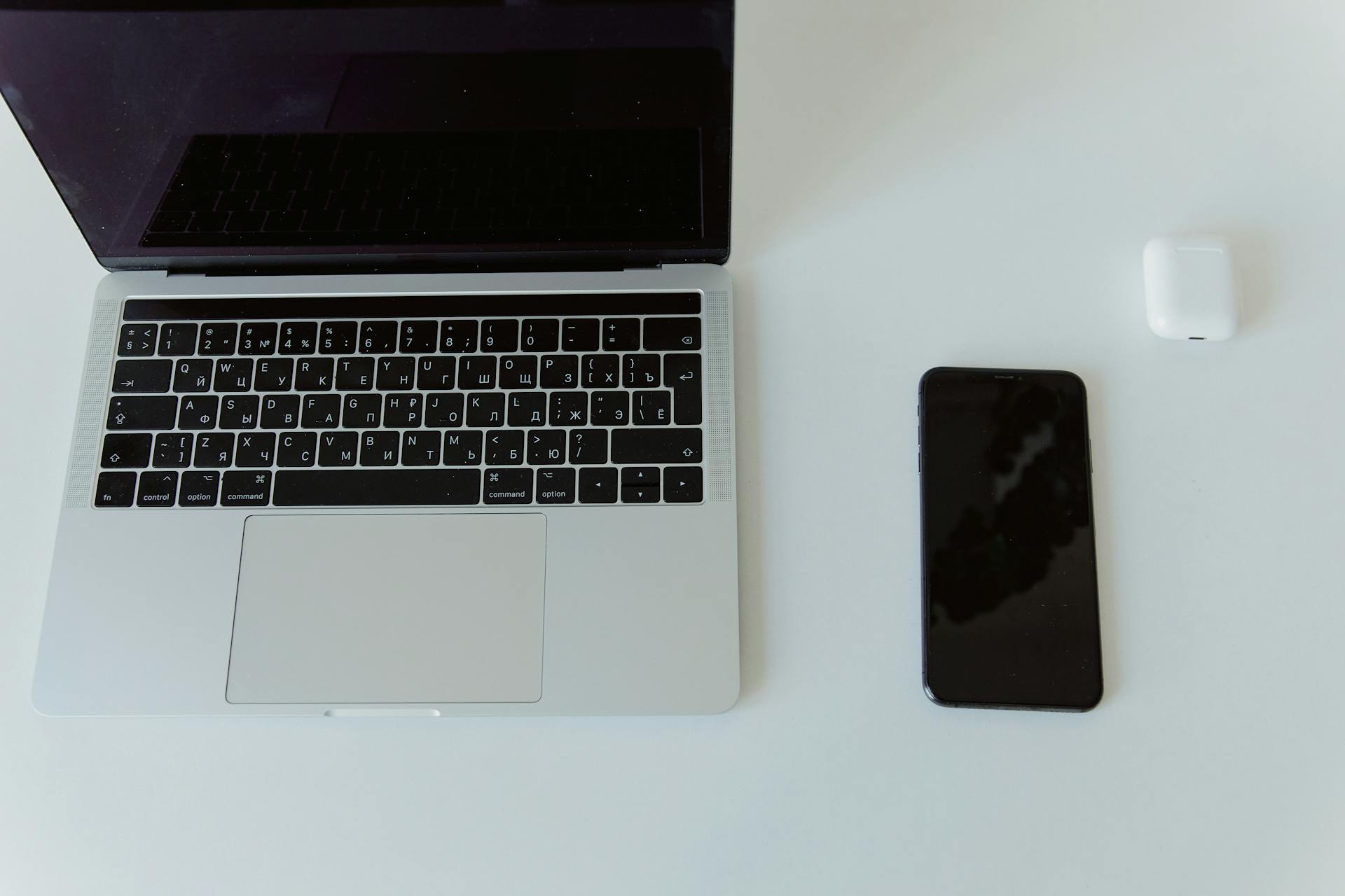 An Iphone and Macbook Pro on White Table