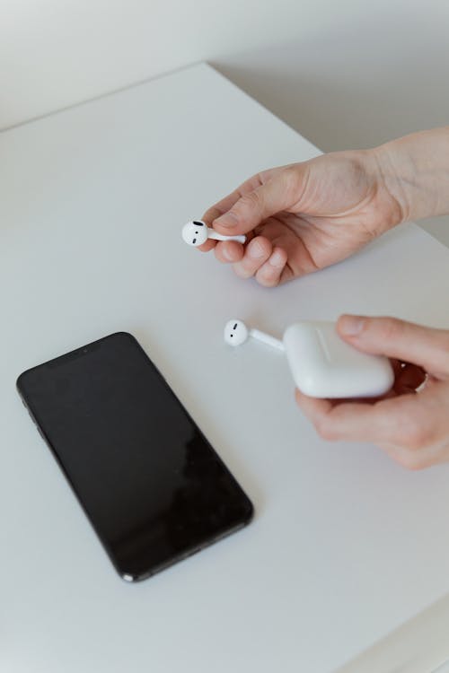 A Close-Up Shot of a Person Holding a Wireless Earphones