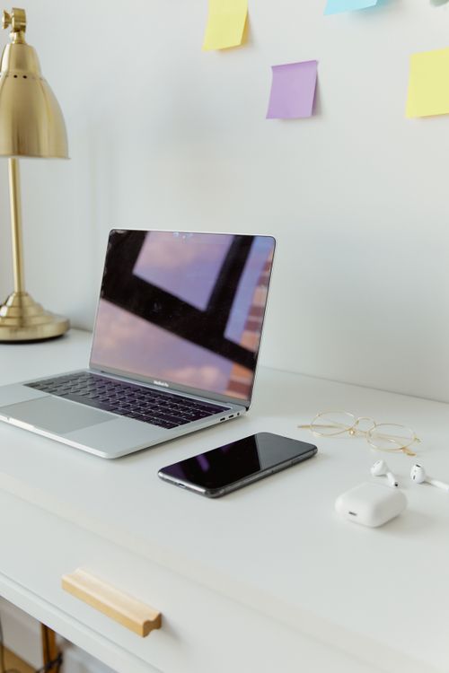 Free Minimalist workspace with a laptop, smartphone, and earphones on a desk with colorful sticky notes. Stock Photo