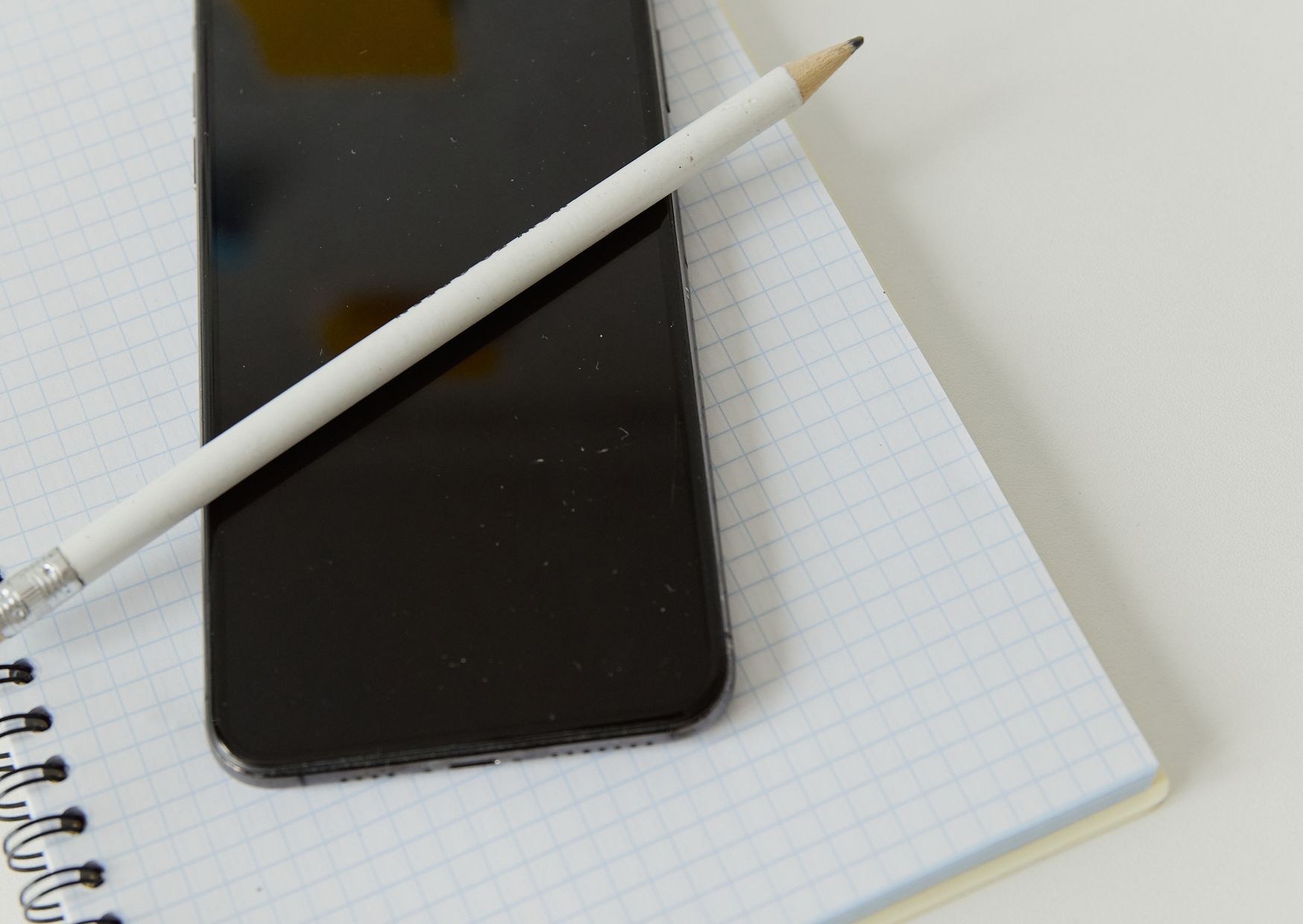 Smartphone posé sur un carnet de notes, utile pour préparer l’arborescence d’une application mobile