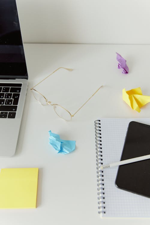 Eyeglasses and Crumpled Sticky Notes on Desk