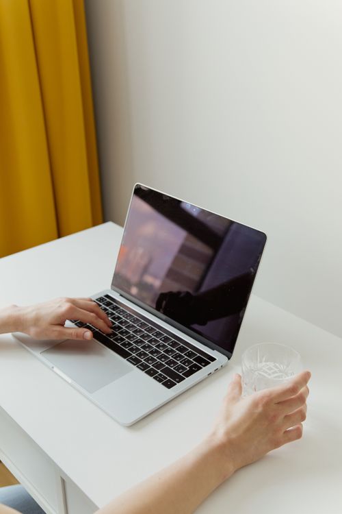 Free Simple minimalist workspace with a laptop and a person working, ideal for office or remote work concepts. Stock Photo