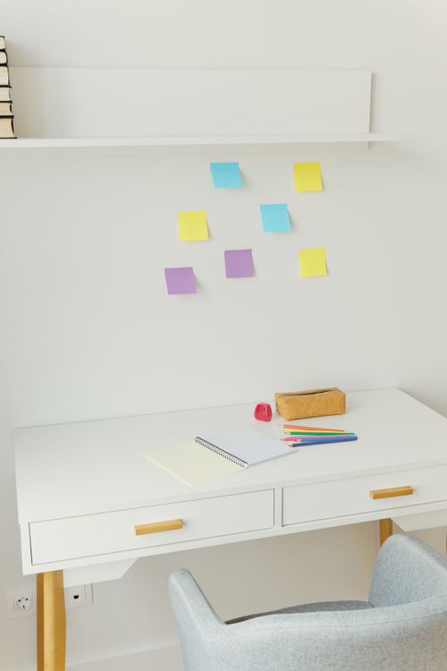 Free Clean and organized desk setup with colorful sticky notes and stationery items. Stock Photo