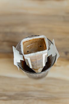Top view of a pour-over coffee filter placed over a cup on a wooden surface.
