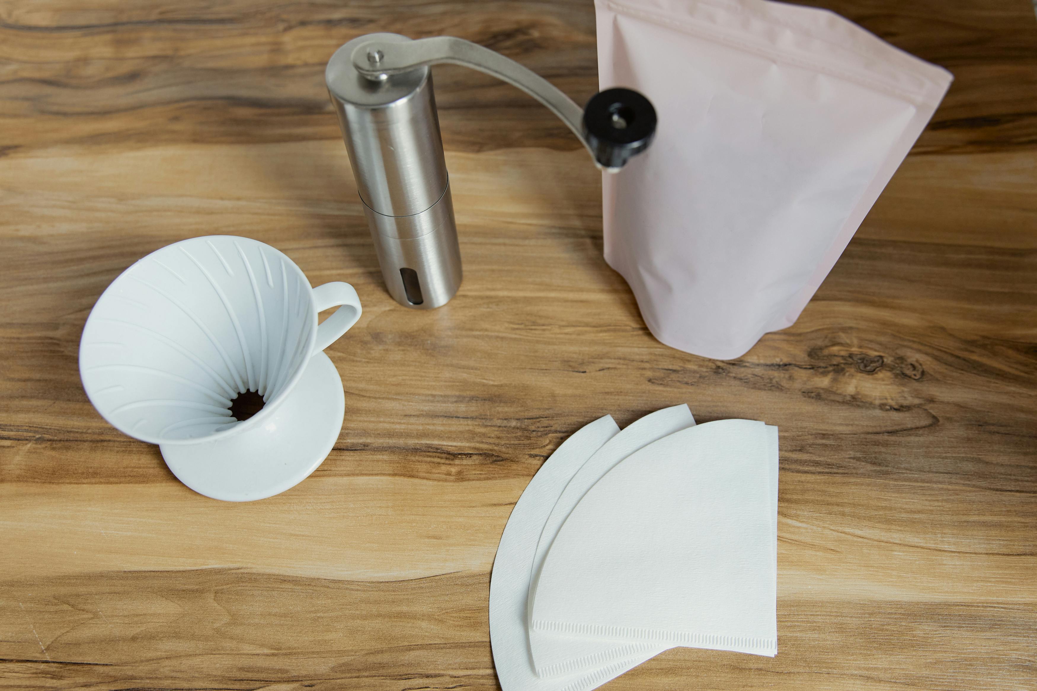 Table en bois avec filtres à café, moulin et dripper pour une préparation artisanale