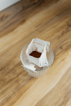 Close-up shot of a coffee drip bag over a glass, ready for brewing fresh coffee.