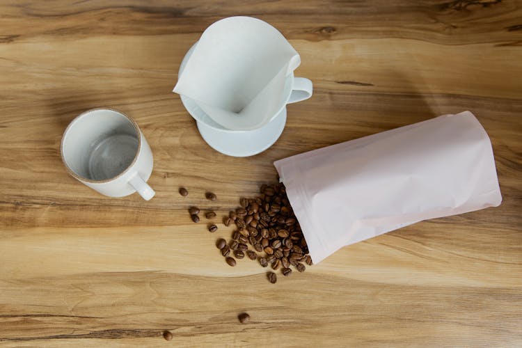 Coffee Beans Spill Over The Wooden Table