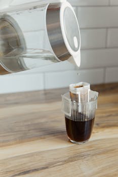 A close-up view of a drip coffee filter brewing fresh coffee in a glass.
