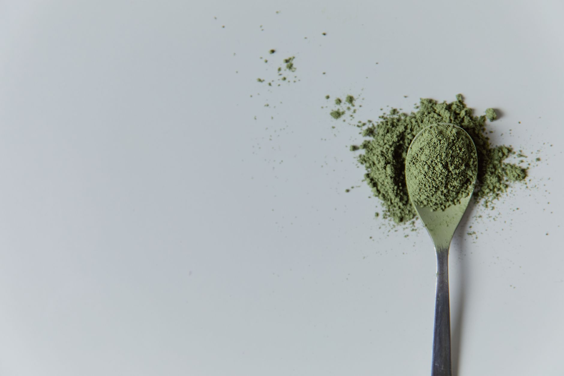 zeolite for post-covid detoxification — High-quality matcha powder on a spoon in a minimalist studio setting, ideal for culinary and wellness themes.