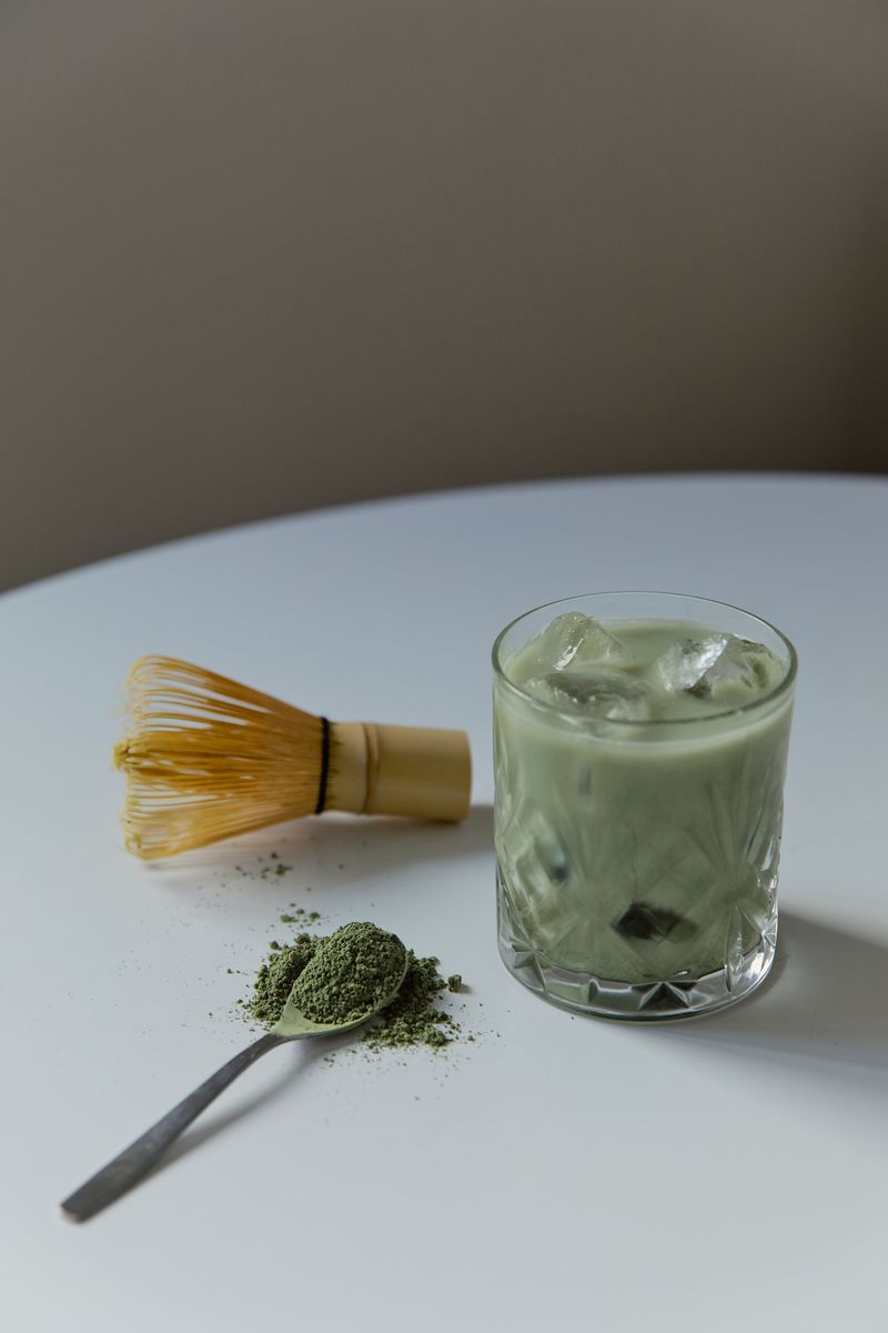 Iced matcha latte with bamboo whisk and green tea powder