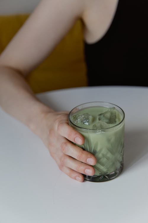 Free A Person Holding a Glass of Cold Milk Tea Stock Photo