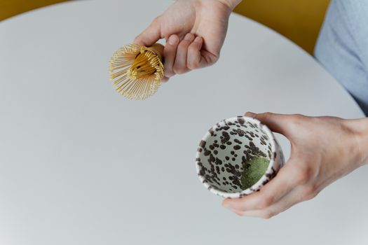 Hands Holding Wooden Chases and a Teacup