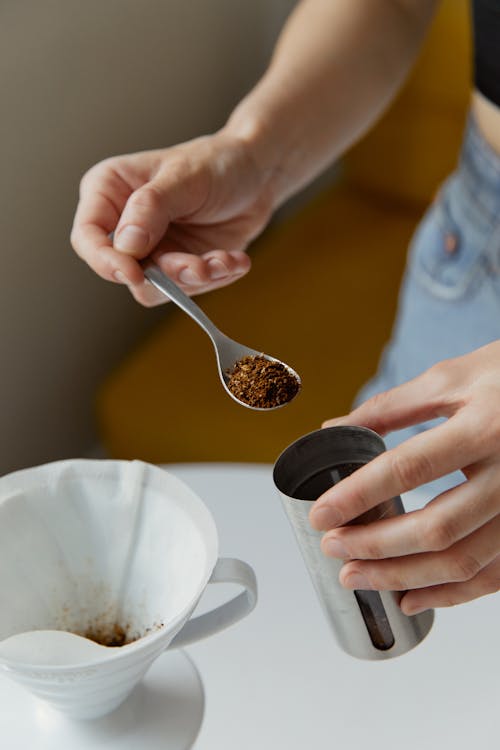 Free A Person Holding a Spoonful of Freshly Grounded Coffee Beans Stock Photo