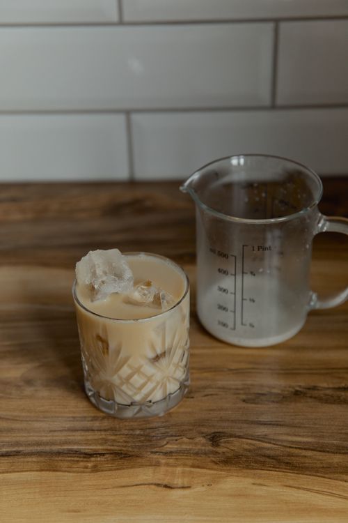 Free Close-up of iced coffee in a glass with a clear pitcher on a wooden table. Stock Photo