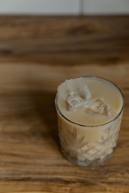 Free Refreshing iced coffee with ice cubes served in a stylish glass on a wooden surface. Stock Photo