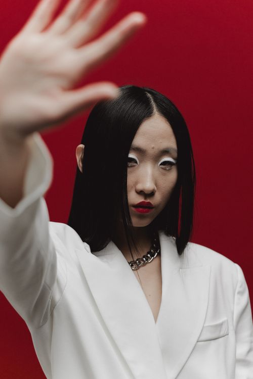Free Fashion portrait of a woman with red lips and bold style against a red background. Stock Photo