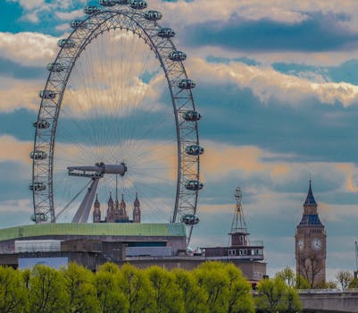 Scenic view of the London Eye and Big Ben on a cloudy day, capturing iconic landmarks of London. by Nikita Khandelwal