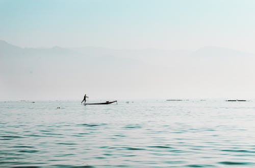 Silhouette of Man on Boat on Water