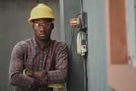 An Electrician Leaning near the Fuse Box