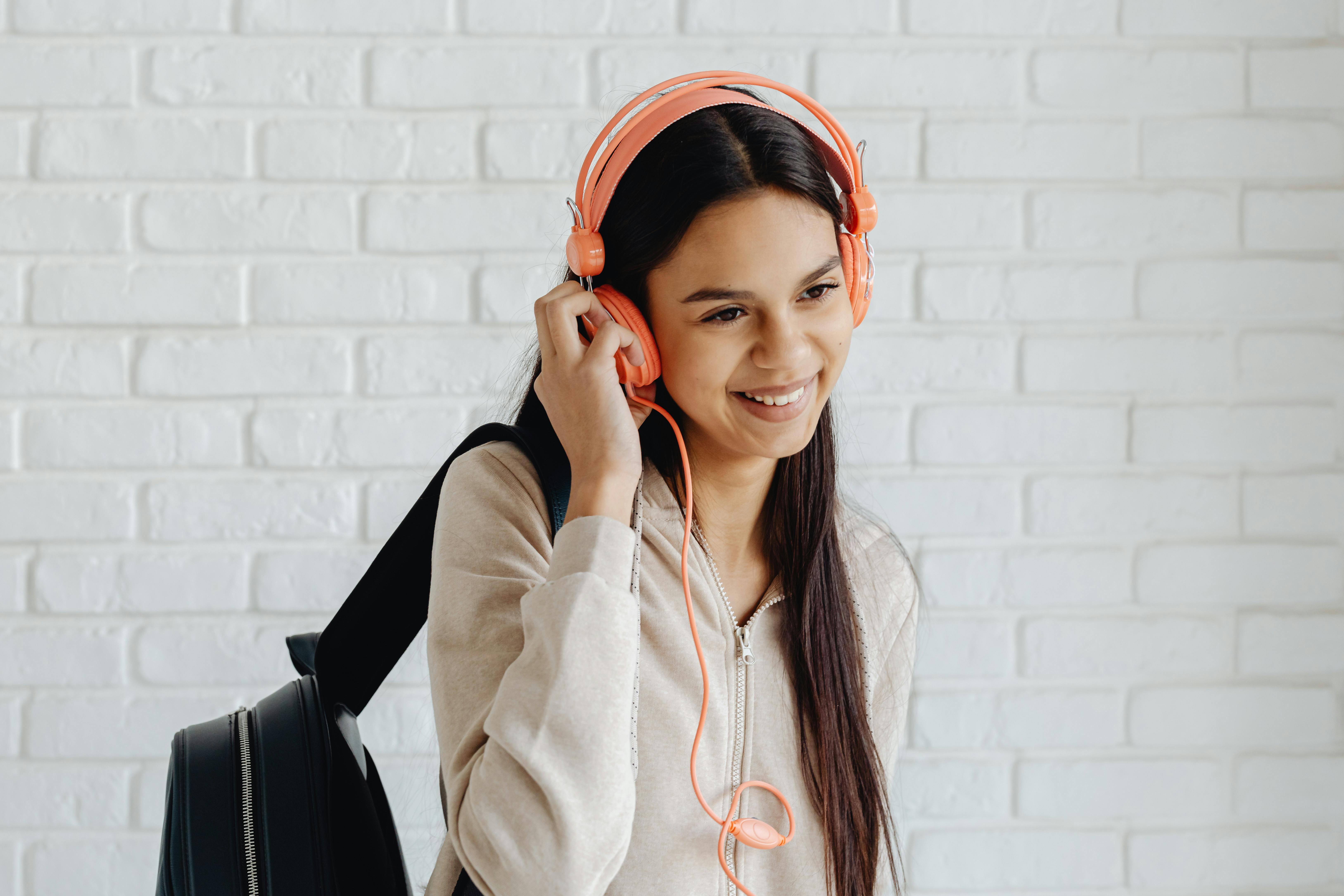 A Happy Young Girl Listening to the Music on Her Headphones · Free ...