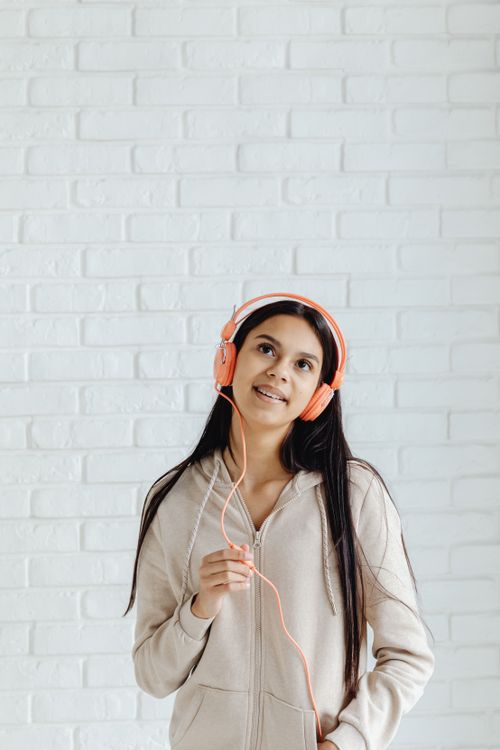 Young Woman Wearing Headphone Standing while Looking Up · Free Stock Photo