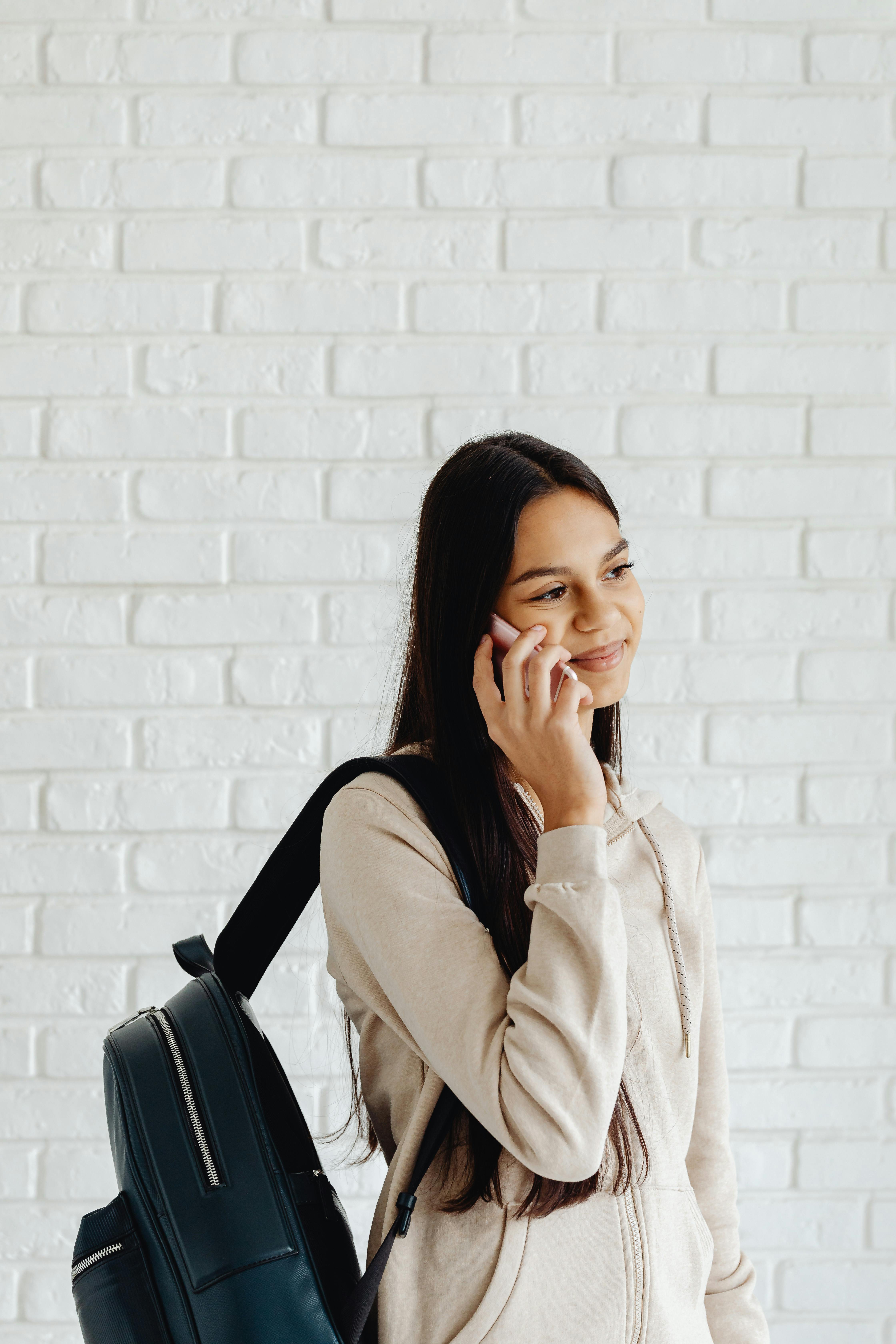 girl with black backpack talking on the phone