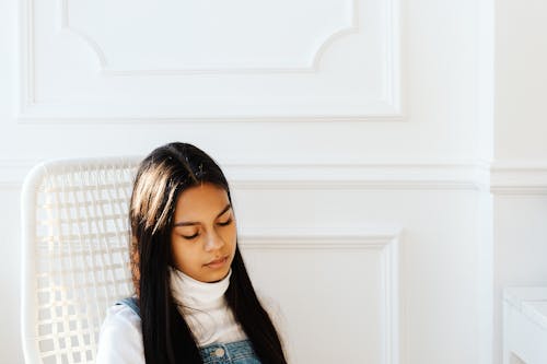 A Woman in White Turtleneck Sleeping on White Chair