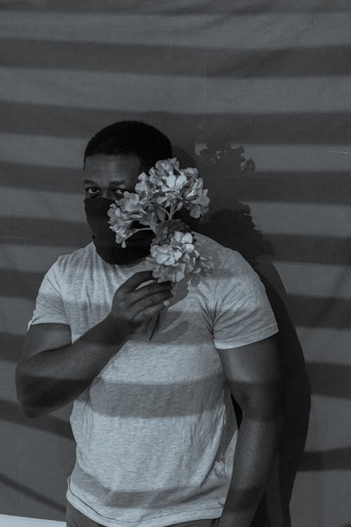 A Grayscale of a Man Holding Flowers
