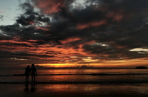 Free Due Persone In Piedi Sulla Spiaggia Silhouette Foto Stock Photo