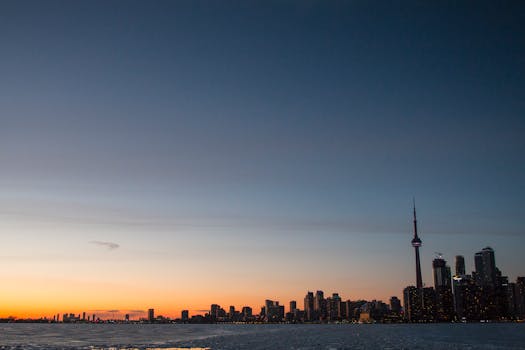 Captivating dusk view of Toronto skyline and CN Tower reflecting over Lake Ontario