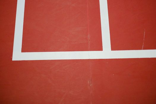 Detailed view of red sports court with crisp white lines, ideal for athletic themes.