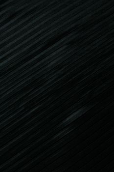 A close-up view of an elegant black textured fabric surface with diagonal lines, perfect for backgrounds.
