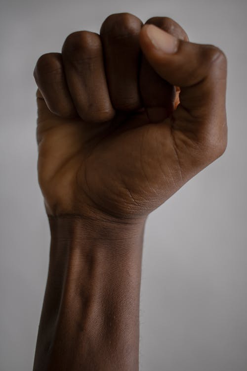 Crop black person raising fist